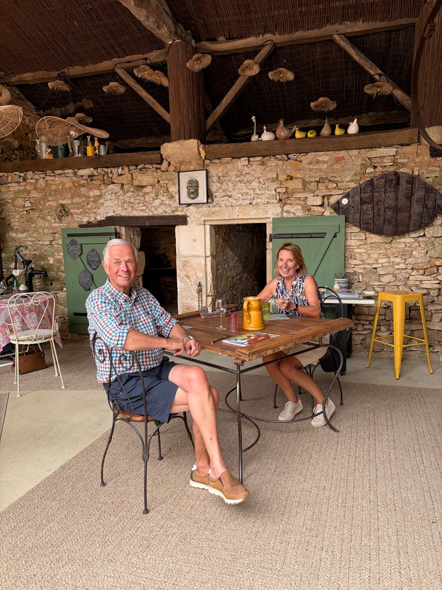 Henriëtte en Cees Bekkers aan tafel onder een oude stenen schuur in de Dordogne